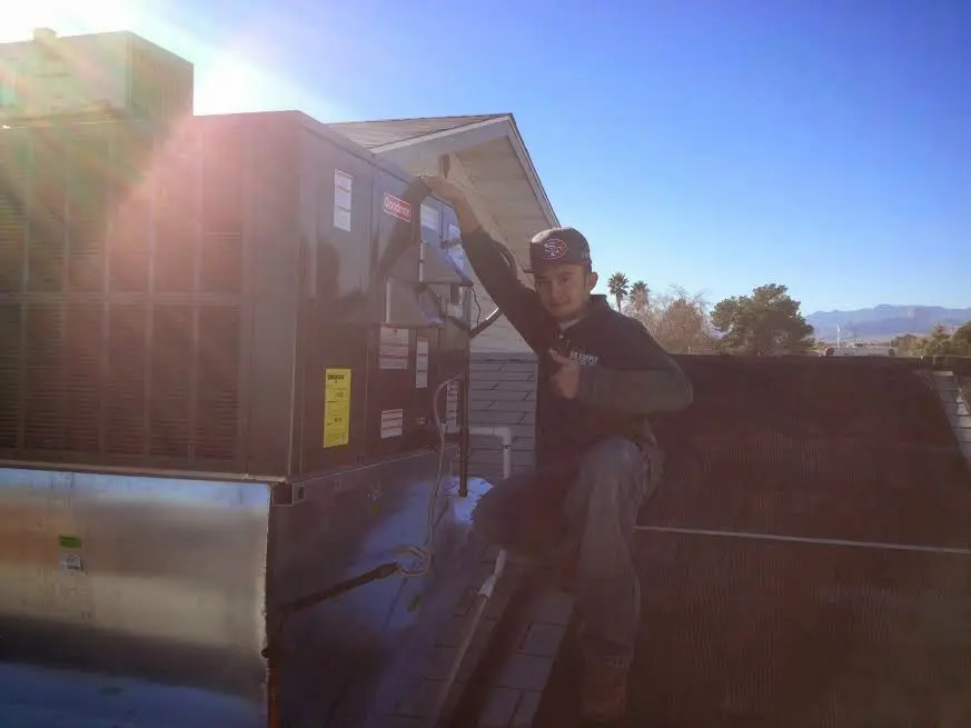 HVAC technician performing Air Duct Cleaning on a rooftop unit in Skokie